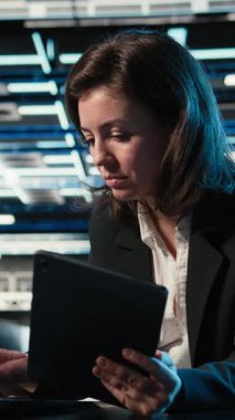 Dikey Veri Merkezi yazılım geliştiricisi aygıtları kullanarak ekipman donanımlarını optimize ediyor. Sunucu çiftliğindeki kadın dizüstü bilgisayar ve tablette programlama betiği çalıştırıyor, sistem parametrelerini ayarlıyor, kamera A