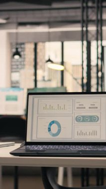 Dikey Video Şirketi verileri boş yönetici ofisinde, modern mobilya ve ofis malzemeleriyle dekore edilmiş profesyonel çalışma ortamında gösteriliyor. Şık ofisteki hiç kimse, doğal ışık.