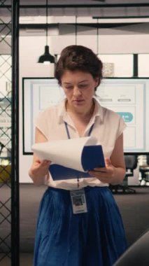 Modern ofis ortamında bağımsız olarak çalışan Dikey Video Kadını, iş zekasını ve KPI gösterge panellerini analiz ediyor. Görsel veriler ve tahmin raporları verimliliği destekliyor.