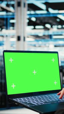 Veri merkezi geliştiricisi tarafından endüstriyel otomasyon sistemlerini izlemek için kullanılan dikey video yeşil ekran laptop. Sunucu merkezi çalışanı ekipman performansını denetlemek için maket not defteri kullanır. Kamera A