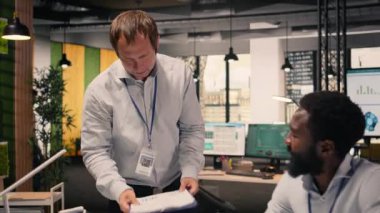 Proje gündemini, hedefleri, görsel verileri, grafikleri ve raporları tartışan profesyonel çalışma ekibi modern bir ofis ortamında görülebilir. Rapor ve tahmin, veri analizi.