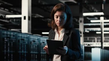 Veri merkezinde yürüyen bir mühendis, tablet kullanarak endüstriyel otomasyon sistemlerini izliyor. Ağ ekipmanı performansını denetlemek için aygıt kullanan sunucu odası bilişim uzmanı, kamera B