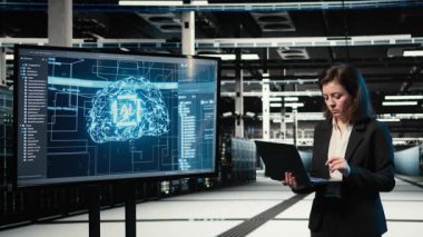 Veri merkezindeki kadın teknisyen yapay zekayı optimize etmek için çabalıyor. Hayal kırıklığına uğramış sunucu merkezi çalışanı yapay zeka teknolojisi ve kamera A 'dan kaynaklanan hatalar yüzünden kaşlarını çatıyor.