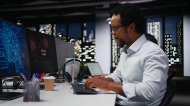 Ofisteki mühendis kod yazarken kritik hata uyarısı alıyor. Silikon Vadisi 'ndeki Afrikalı Amerikalı işçi yazılım arızalarını gidermek ve sistem çökmelerini çözmek için bilgisayar kullanıyor.