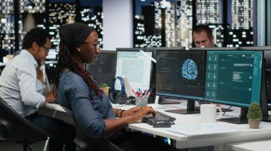 Kodlama görevlerinde yardım almak için büyük dil modeli uygulaması kullanan kadın programcı. AI LLM sohbet robotu PC GPT yazılımıyla etkileşime geçen Afrikalı Amerikalı kadın.