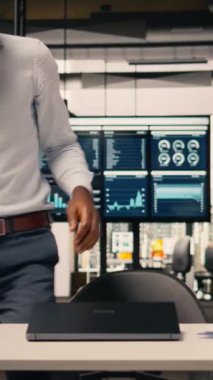 Şirket ofisindeki stratejik planlama oturumunda çizelge ve grafikleri analiz eden dikey video çalışanı raporları ve analitik gösterge panelini tahmin ediyor. Hedefleri ve görev yönetimini destekleyen adam.