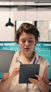 Dikey Video Portresi çok ırklı ekibi, ofiste birlikte çalışıyorlar, iş raporlarını gözden geçiriyorlar, görsel verileri inceliyorlar. Kurumsal işbirliği, öngörü ve planlama, örgütsel hedeflere ulaşmak