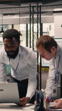 Vertical Video Corporate çalışanları, grafikler, dizüstü bilgisayardaki KPI panelleri, planlama, kaynak tahsisi ve üretkenlik için işbirliği, modern ofis çalışma alanı, çeşitli işçiler.