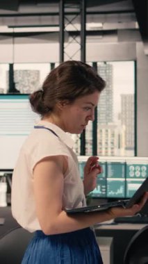 Dikey Videolu Kadın modern ofiste yerde volta atıyor ve sabırsız, huzursuz ve gergin olduğu için ileri geri yürüyor. Odaklanmış ve endişeli kadın işçi, iş zekası..