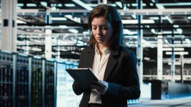 Veri merkezi yazılım geliştiricisi tablet üzerinde kodlama yapıyor, artırılmış gerçeklik dijital ikizi yaratmak için sondaj kulesini tarıyor. Sunucu çiftliğindeki kadın aygıt üzerinde programlama betiği çalıştırıyor, VFX üstüste, kamera B