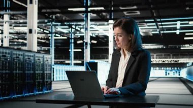 Veri merkezi mühendisi bilgisayarların bağlantı sorunlarını çözmek için dizüstü bilgisayarda klavye kullanıyor. Sunucu merkezi uzmanı sistem günlüklerini analiz etmek, dişli hatalarını düzeltmek, kamera A için dizüstü bilgisayarı kullanıyor.