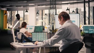 Profesyonel adam, iş istihbaratı, ofiste görsel veriler, analitik gösterge paneli, performans ölçümleri, tahmin raporları, parasal veriler, kaynak tahsisi ve strateji planlamasına yardım etme.