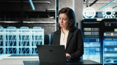 Veri Merkezi kadın programcısı, elektronik sorunları çözmek için dizüstü bilgisayar ve AR viralizasyonunu kullanıyor. VFX bileşikleri, kamera B, vites sistemi hatalarını düzeltmek için masadaki dizüstü bilgisayarı kullanan sunucu merkezi çalışanı