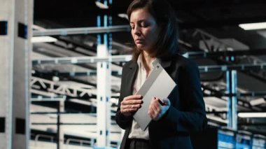 Otomasyon, tablet ve mühendis veri merkezinde yürüyor, endüstriyel sistemleri izliyor. IT uzman sunucu odası IT uzmanı ağ ekipman performansını denetlemek için aygıt kullanıyor, kamera B