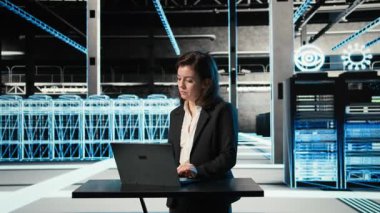 Veri Merkezi kadın programcısı, elektronik sorunları çözmek için dizüstü bilgisayar ve AR viralizasyonunu kullanıyor. VFX bileşiklerini, kamera A 'yı düzeltmek için masadaki dizüstü bilgisayarı kullanan sunucu merkezi çalışanı