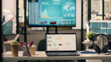 KPI 'ler ekranda boş yönetici ofis ortamında, modern mobilya ve profesyonel malzemelerle dekore edilmiş çalışma ortamında gösteriliyor. Şık bir ofiste, parlak bir iç mekanda kimse yok..