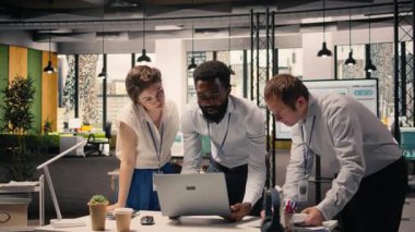 Şirket profesyonelleri, analiz çizelgeleri, dizüstü bilgisayardaki KPI panelleri, planlama için işbirliği, kaynak tahsisi ve üretkenlik, modern ofis çalışma alanı, çeşitli işçiler.