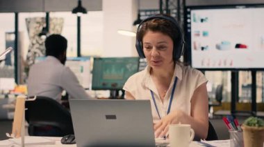 İş adamı video konferansında kulaklıkla el sallıyor, bilgi veriyor ve ekibiyle iletişim kuruyor. Video çağrısında iş istihbaratıyla örgütsel işbirliği.