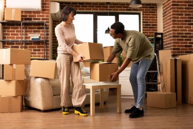 Muhtelif eşler karton kutularla çevrili tuğla duvar evine taşınıyor. Genç siyahi erkek ve beyaz kadın eşyalarını boşaltıyor ve birlikte yeni bir apartmanda hayat kurma sürecinin tadını çıkarıyorlar..