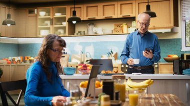 Sıradan bir mutfak ortamında akıllı telefon kullanan olgun bir insan. Emeklilikten sakin bir keyif alıyor. Huzurlu bir gülümsemesi olan yaşlı bir adam rahatlamış refahı ve pozitif yaşam tarzını ön plana çıkarıyor. Kamera A.