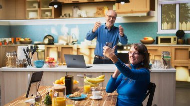 Yaşlı kadın aptalca davranıyor ve mutfakta kendi fotoğrafını çekiyor, kocası ona gülüyor ve kır evinde birlikte emekliliğin tadını çıkarıyor. Karısı akıllı telefondan fotoğraflarda gülümsüyor. Kamera A.