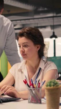 Proje planlama ve görev yönetimi konusunda işbirliği yapan dikey video sektörü profesyonelleri. Bir kurumsal ofis çalışma alanında dizüstü bilgisayarda görüntülenen görsel veriler, grafikler ve grafikler, öngörü.