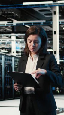 Dikey video donanım donanımı optimize etme, yapay zeka ve veri merkezindeki mühendisin gülümseme portresi. Sistem parametreleri ayarlanıyor, sunucu merkezinde yapay zeka öğrenme teknolojisi ve mutlu çalışan