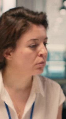 Temel fikirleri belgeleyen ve deftere yazan, görevleri planlayan ve KPI için araştırma yapan dikey video kadın çalışanı. İş istihbaratı için hedefleri yansıtan el yazısıyla yazılmış notlar hazırlıyorum..