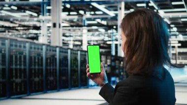 Veri merkezi yöneticileri tarafından sondaj sorunlarını çözmek için kullanılan krom tuşlu akıllı telefon. Sunucu merkezindeki kadın sistem günlüklerini analiz etmek için izole edilmiş cep telefonu kullanıyor, bilgisayar hatalarını düzeltiyor, kamera A