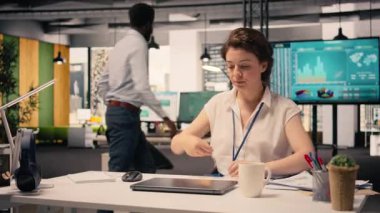 Şirket ofisindeki kadın işçi gelir verilerini ve performans ölçümlerini analiz ediyor. Analiz ve çizelge üzerinde çalışan kadın, kaynak tahsisi ve iş stratejisini destekliyor.