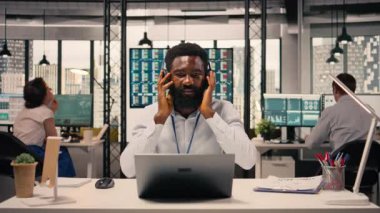 Modern ofiste müzik kulaklığı takan siyahi bir çalışan, çalışma alanı neşeli ve keyifli. Stres atmak için şarkı dinleyen bir adam. Dengeli kurumsal yaşam tarzı.