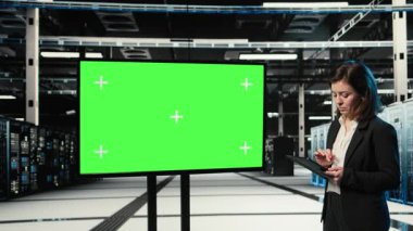 Mokup monitör, AR kontrol paneli ve veri merkezindeki platformları düzenleyen yönetici. Donanım ayarları ayarlanıyor, yeşil ekran görüntüsü ve sanal kaplama kullanılarak sunucu çiftliği çalışanı, kamera A