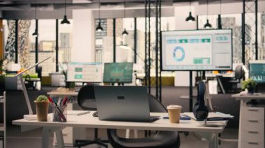 Modern masa kurulumu ve ofis malzemeleri ile profesyonel iş içi mobilya ve kırtasiyeli rahat ofis alanı. Büyük pencereler parlak doğal ışık sağlar, şehir merkezinden ufuk çizgisi.