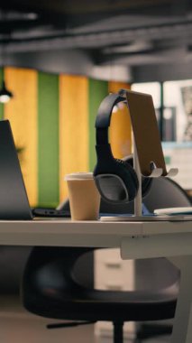 Modern mobilyalı iş ortamı için dikey video boş ofis, şık dekorasyonlu parlak açık alan ve masa kurulumunda kırtasiye malzemesi. Pencereler üretkenlik için doğal ışık sağlar