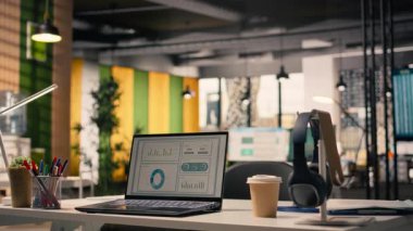 Bilgisayarlı ekranda çalışan performans ölçümleri boş açık ofiste, malzeme ve aletlerle dolu, modern iç dekorasyonda mobilya ve doğal ışıkla dekore edilmiş bir masa. Çalışma ortamı.