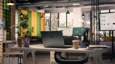 Boş iş bürosu, malzemelerle çalışma ortamı, modern mobilyalar ve doğal ışık. Yönetici ofisi, rahat masa düzeni, kırtasiye ve dizüstü bilgisayar, kurumsal açık plan..