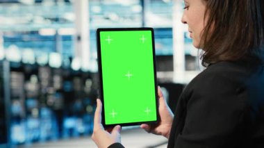 Veri merkezi yönetimi tarafından sunucu yükü dengesini optimize etmek için kullanılan yeşil ekran tableti. Sistem parametrelerini ayarlamak ve verimliliği arttırmak için model aygıtı kullanan sunucu çiftliği bilişim uzmanı, kamera B