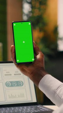 Dikey video dikey yeşil ekran, akıllı telefon, siyah çalışan, ofiste çalışan, araştırma ve geliştirme, küresel iş, kurumsal yaşam tarzı. İş bilgileri, görev yönetimi, parasal veriler.