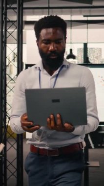 Modern ofiste çalışan dikey video işadamı iş istihbaratı ve KPI metrikleri, görsel veriler, grafikler ve örgütsel planlamayı ve profesyonel iş akışını destekleyen tahminler raporlarını analiz ediyor.