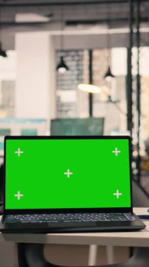 Kurumsal çalışma ortamında dizüstü bilgisayarı olan boş yönetici masasında dikey video krom anahtar ekranı. Modern mobilyaların, dekoratif detayların ve ofis malzemelerinin olduğu geniş pencereli bir yer.