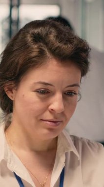 Dikey Video Kadını profesyonel, veri analiz raporları, KPI gösterge panelleri, masadaki dizüstü bilgisayarlar, modern ofis, verimliliği destekleme, iş zekası, stratejik karar verme, görev yönetimi.