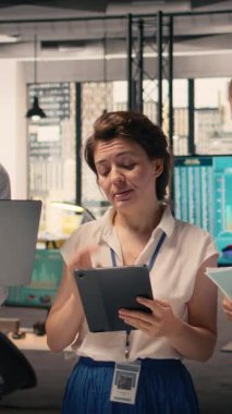 Çalışan ekibin dikey video portresi veri analizi sonuçlarını ve KPI metriklerini şirket çalışma alanında analiz ediyor. Strateji, performans raporlama ve geliştirme konularında işbirliği yapan çeşitli iş adamları.