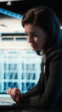 Veri merkezinde yükleme dengeleme yapan sunucu, dizüstü bilgisayar ve yazılım geliştirici dikey video optimizasyonu. Sistem parametreleri, dizüstü bilgisayar ve kadın masadaki sunucu çiftliğinde verimliliği ve kamerayı arttırıyor