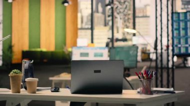 Boş iş bürosu, malzemelerle çalışma ortamı, modern mobilyalar ve doğal ışık. Yönetici ofisi, rahat masa düzeni, kırtasiye ve dizüstü bilgisayar, kurumsal açık plan..