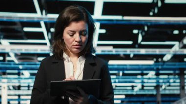 Veri merkezini kapatın DevOps mühendisi tablet kullanarak sunucu yükü dengelemeyi optimize ediyor. Verimliliği arttırmak için sistem parametrelerini ayarlayan sunucu tarım işçisi, kamera B