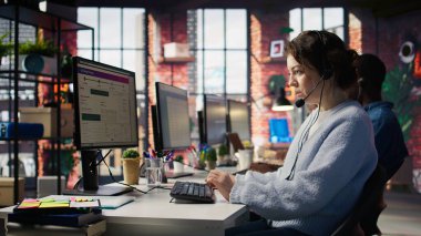 Müşteri destek çalışanları, teknik sorunlara teşhis koyarak müşterilere yardımcı oluyor. Ofiste kulaklık takan çağrı merkezi ajanları arıza giderme ve şikayet çözümü yapıyorlar.