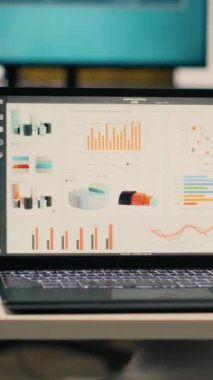 Dikey Video Şirketi verileri boş yönetici ofisinde, modern mobilya ve ofis malzemeleriyle dekore edilmiş profesyonel çalışma ortamında gösteriliyor. Şık ofisteki hiç kimse, doğal ışık.