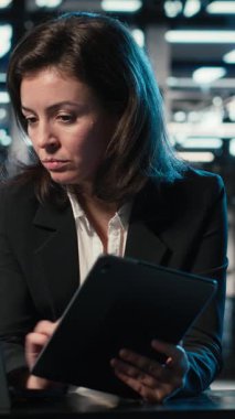 Dikey Veri Merkezi yazılım geliştiricisi aygıtları kullanarak ekipman donanımlarını optimize ediyor. Sunucu çiftliğindeki kadın dizüstü bilgisayar ve tablette programlama betiği çalıştırıyor, sistem parametrelerini ayarlıyor, kamera B