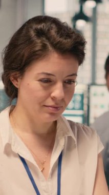 Bir kurumsal ofis çalışma alanına uyum sağlamak için para verilerini ve vergileri inceleyen dikey video kadın profesyonel. Görsel veriler, çizelgeler ve grafikler risk değerlendirmesini ve organizasyonel planlamayı destekler.