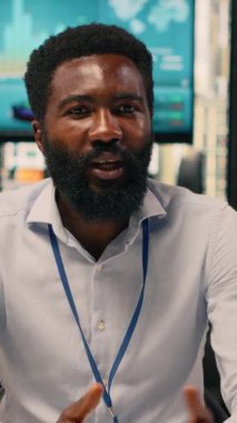 Dikey Video Afrikalı Amerikalı iş adamı laptopta online toplantıya katılıyor. Video konferansı, hedefleri ve organizasyonel planlamayı, uyumu destekleyen içgörüler ve iş zekasını gösteriyor.